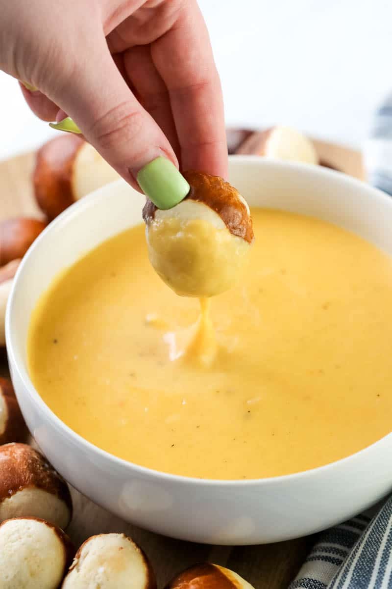 dipping pretzels into beer cheese dip 