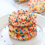 Three Funfetti cake mix cookies stacked on a plate.