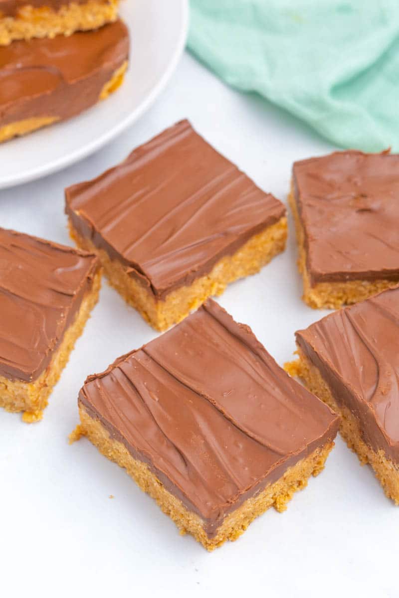 Chocolate covered peanut butter bars cut into squares on white table