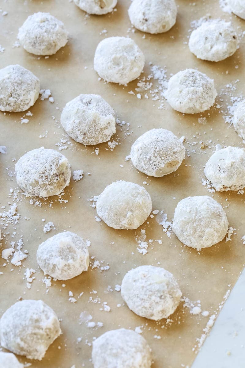 snowball cookies sitting on parchment paper.