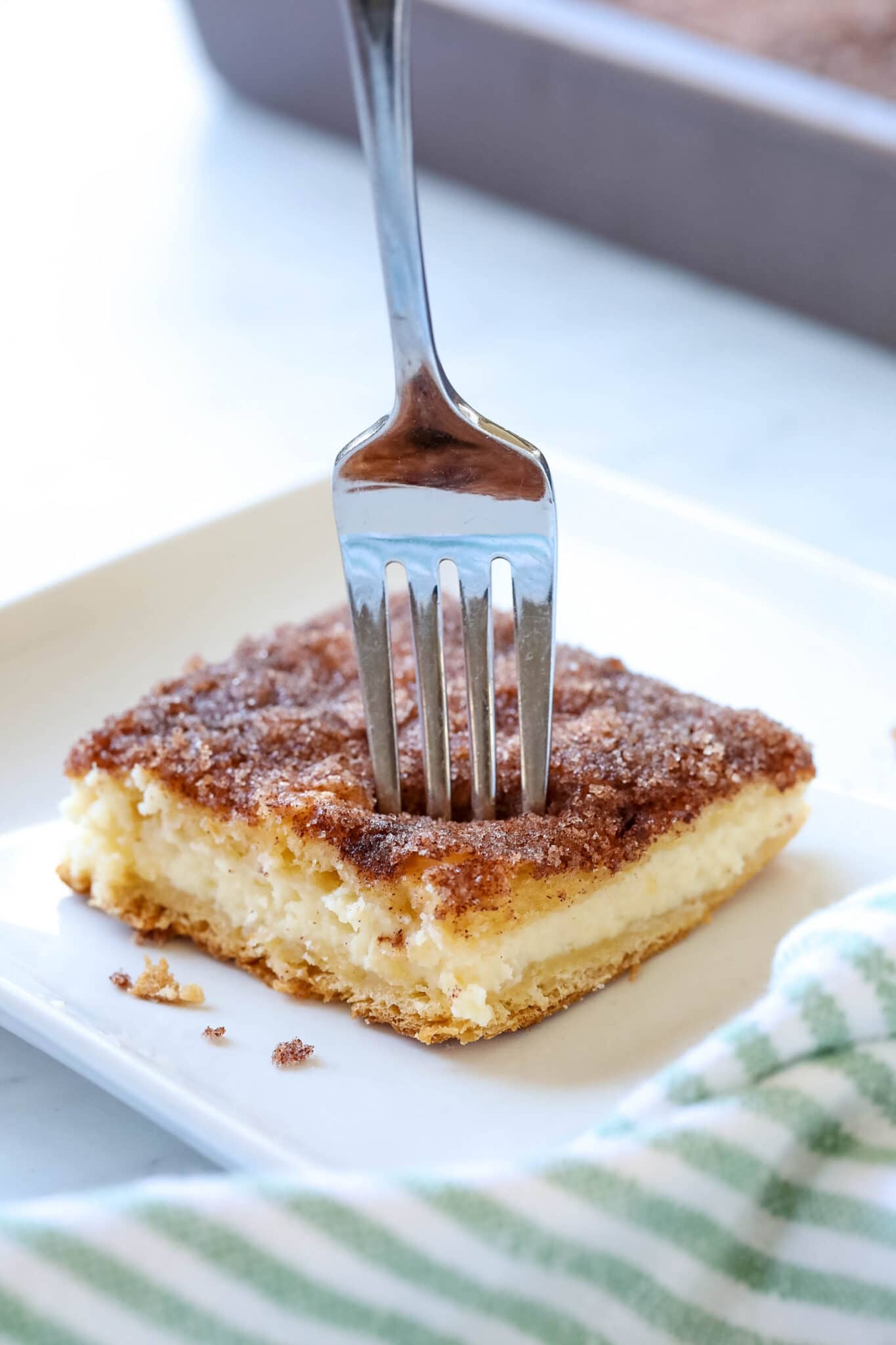 sopapilla cheesecake bars with a fork sticking out