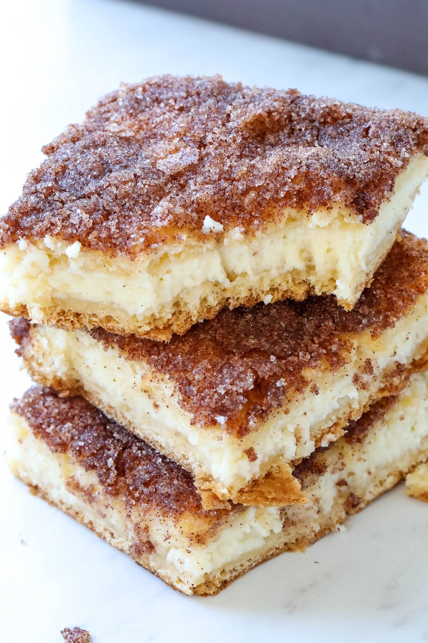 close up of sopapilla cheesecake bars topped with cinnamon sugar 