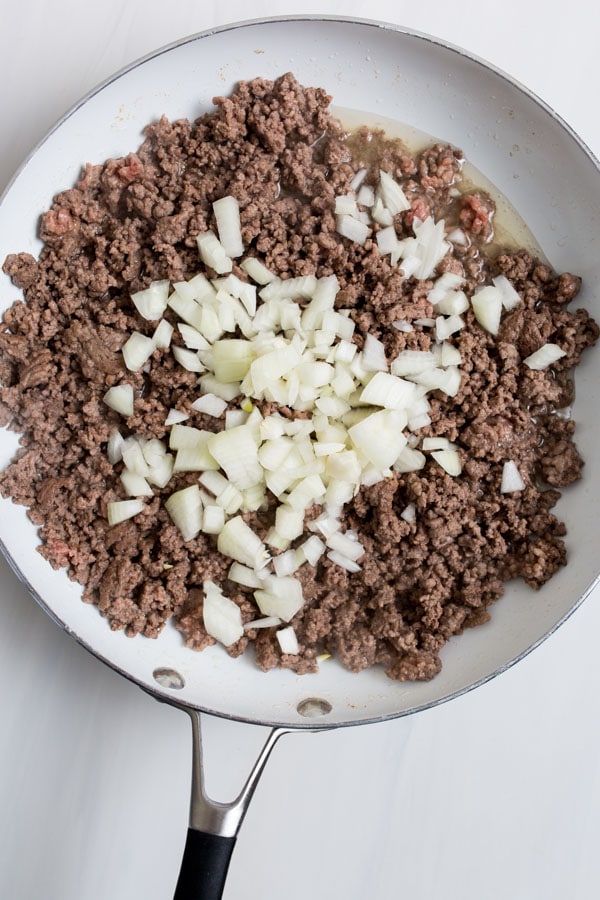 cooking up the ground beef and onions in a skillet 