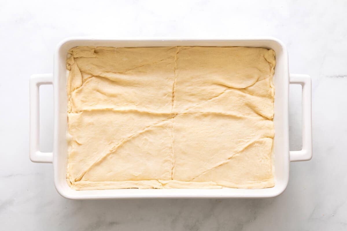 Crescent roll dough top added to baking dish.