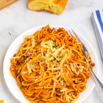 top shot of spaghetti in red meat sauce on white plate