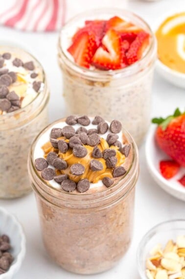 top shot of three mason jars with overnight oats and various toppings