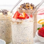 overnight oats with chia seeds in mason jar with spoon, topped with sliced strawberries