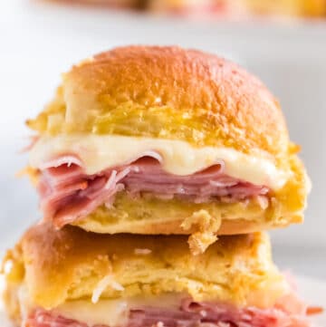 Two ham and swiss sliders on top of each other.
