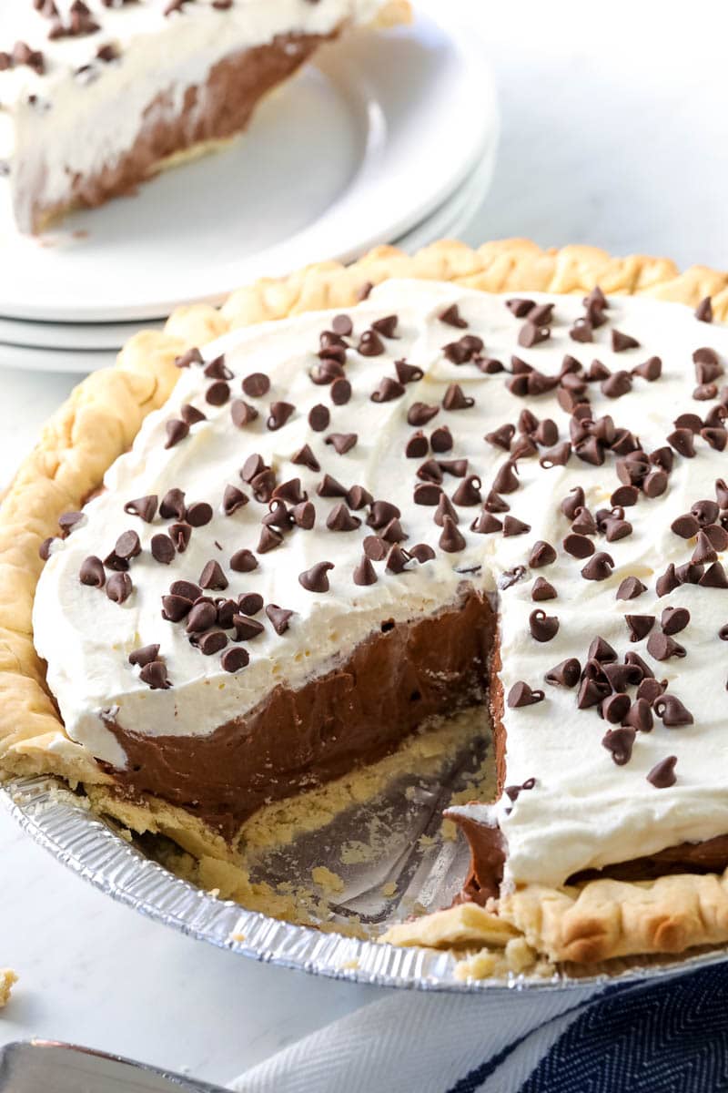 Chocolate Cream Pie in pie plate with a piece of pie cut 