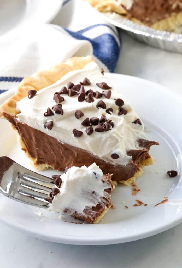 A slide of  chocolate cream pie with a bite on a fork 