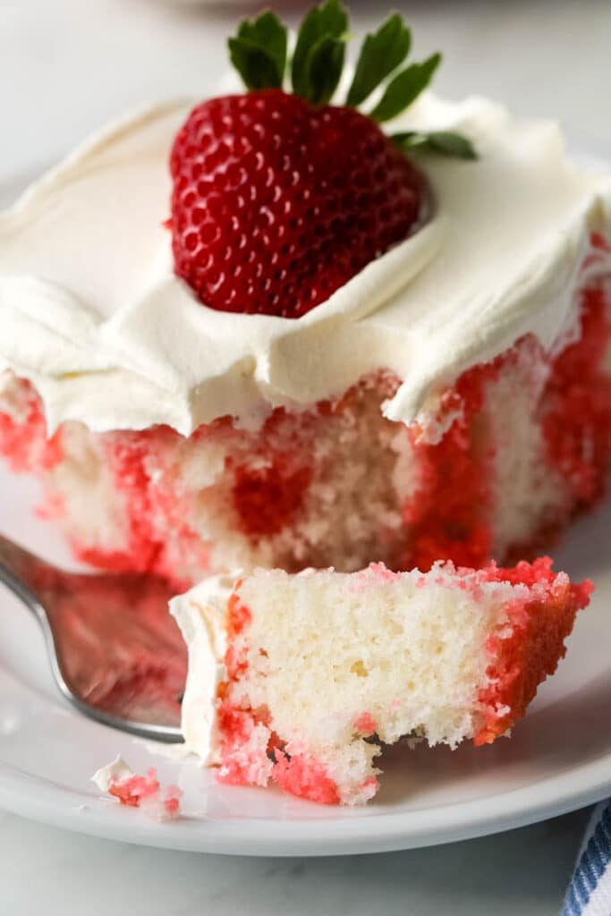 strawberry jelly poke cake on a white plate 