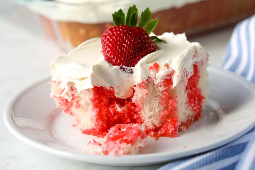 A slice of strawberry jello poke cake.