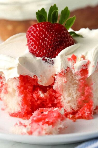 A slice of strawberry jello poke cake.