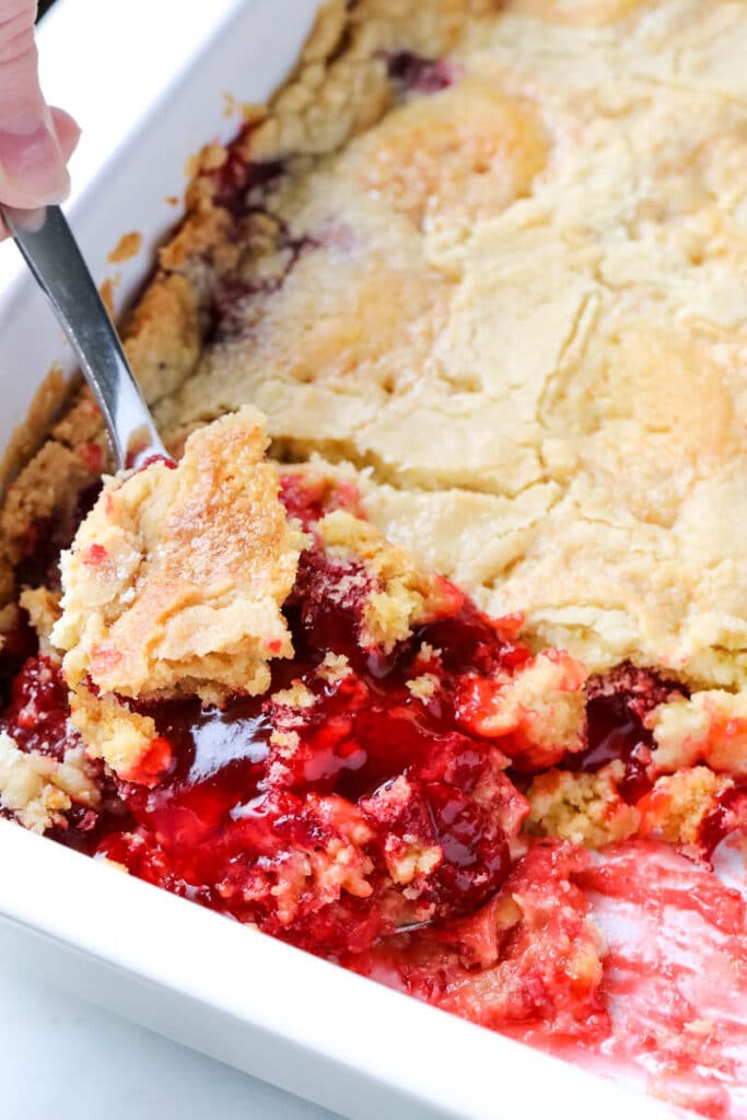 spoon digging into strawberry dump cake 
