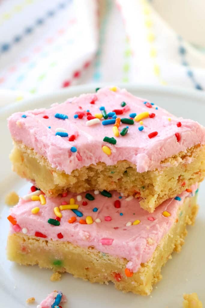 funfetti sugar cookie bars with a bite taken out of one