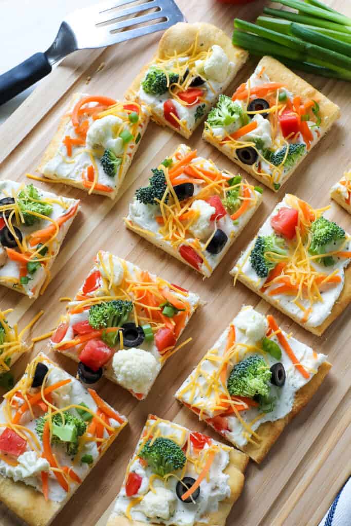 slices of vegetable pizza on a cutting board 