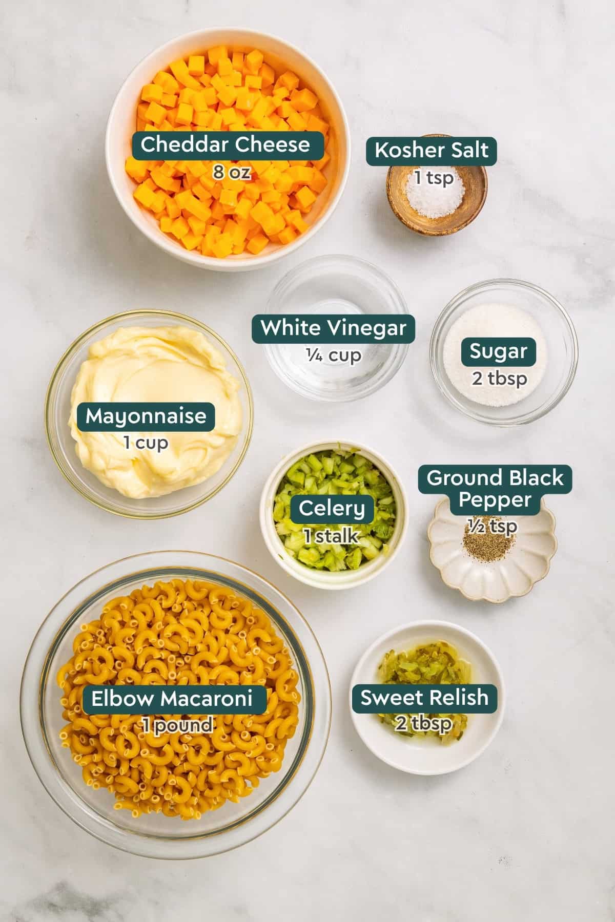 Ingredients for macaroni pasta salad, including cheddar, salt, vinegar, sugar, mayo, celery, black pepper, relish, macaroni.