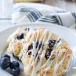 Bisquick Blueberry Biscuits on white plate with tea towel in background