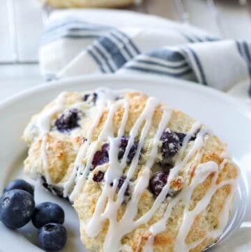 Bisquick Blueberry Biscuits on white plate with tea towel in background
