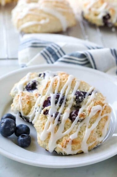 Bisquick Blueberry Biscuits on white plate with tea towel in background