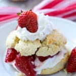 strawberry shortcake with whipped cream and strawberries on a white plate