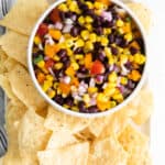 Overhead shot of Black Bean and Corn Salsa in bowl with tortilla chips.