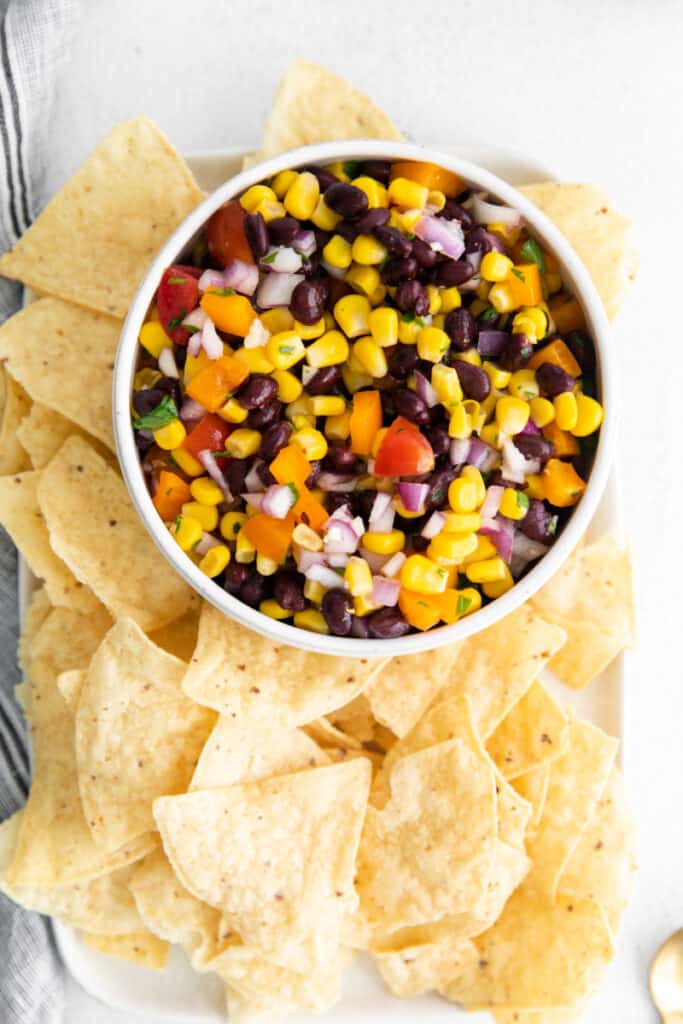 Overhead shot of Black Bean and Corn Salsa in bowl with tortilla chips.
