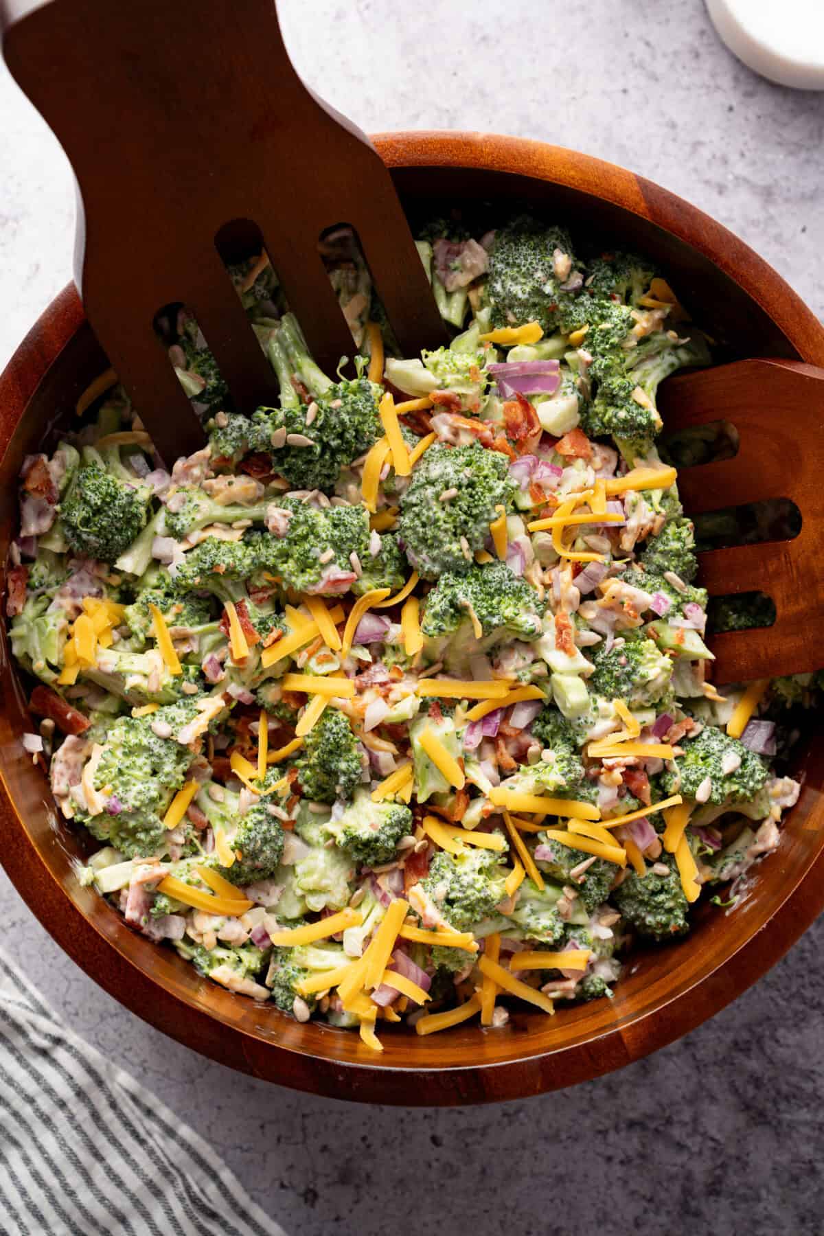 Broccoli salad with bacon and cheddar in wooden bowl.