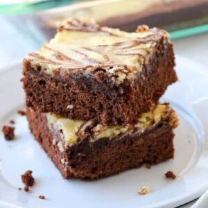 Two marble brownies stacked on a plate.
