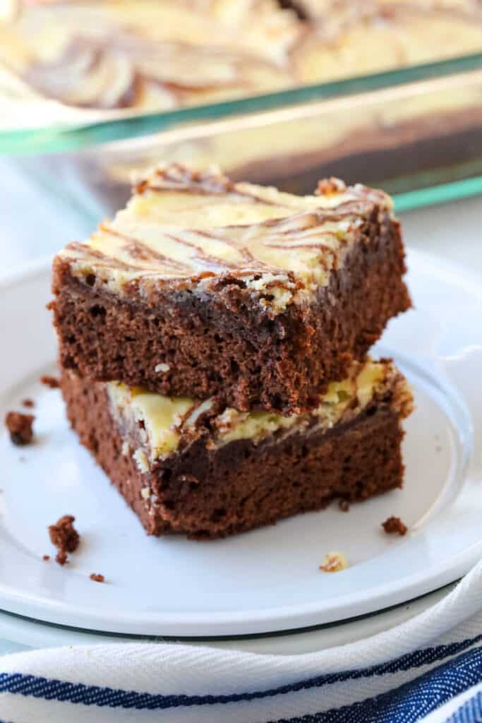 A stack of brownies on a white plate.