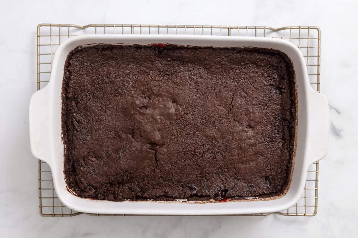 Chocolate cherry dump cake in pan on wire rack.