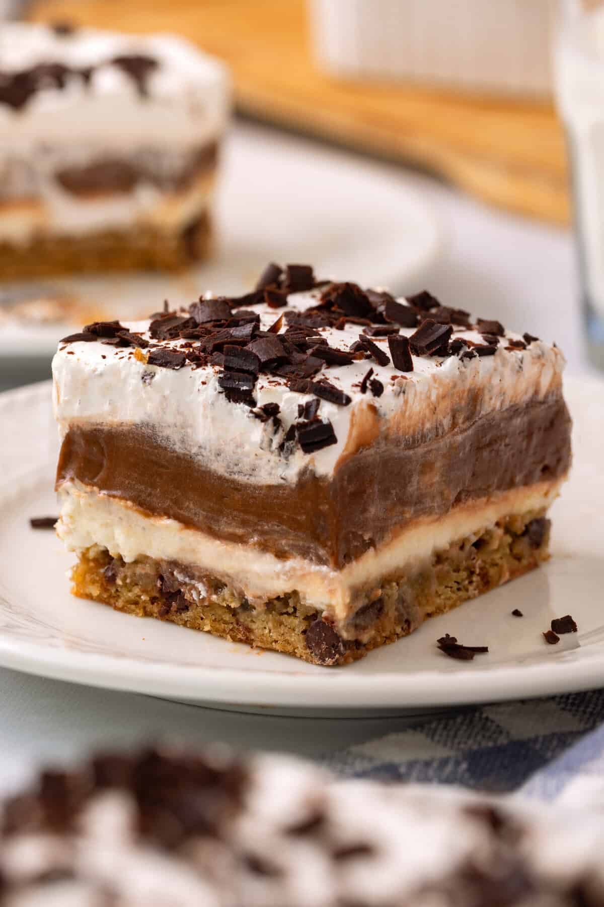 Slice of chocolate delight on plate topped with chocolate shavings.