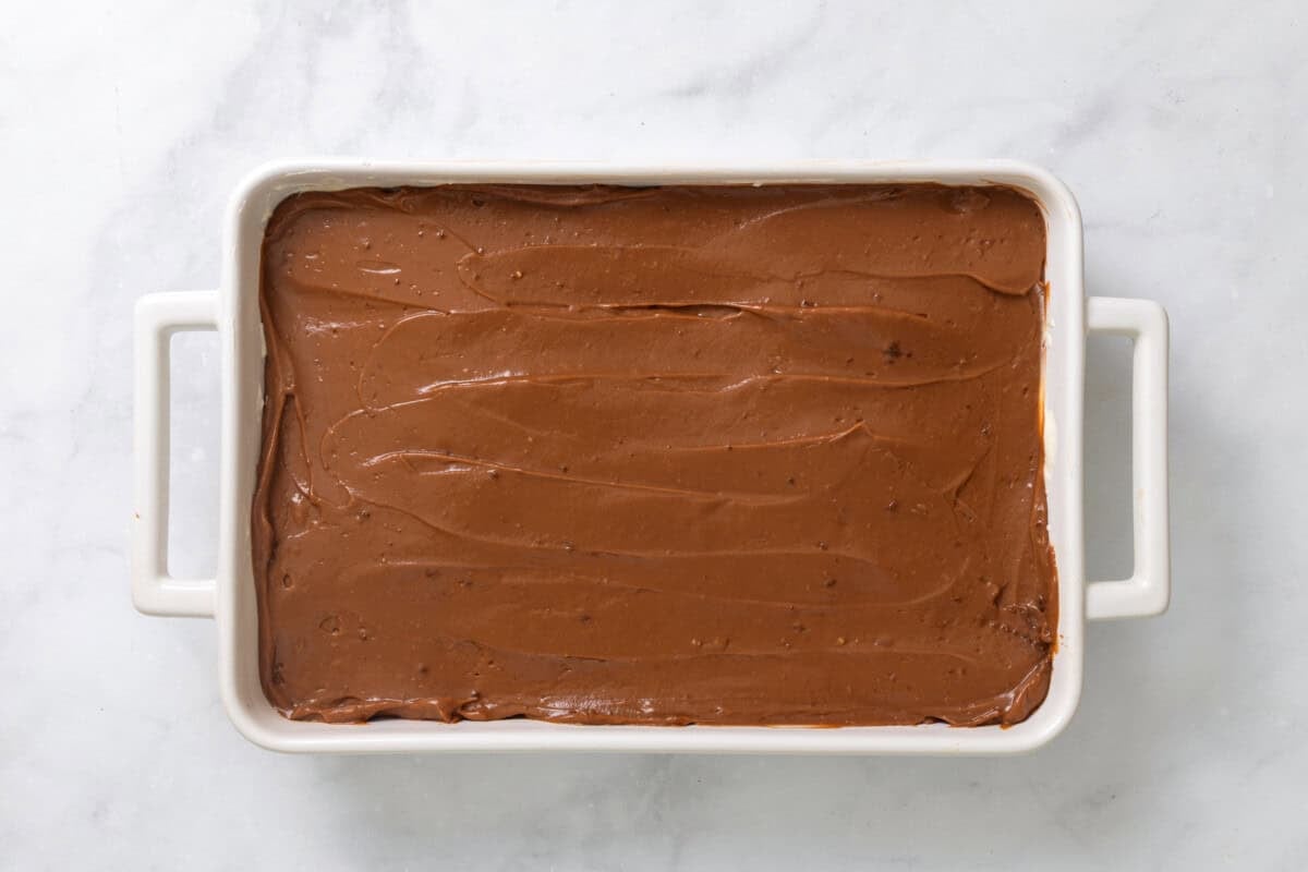 Chocolate pudding layer spread into pan.