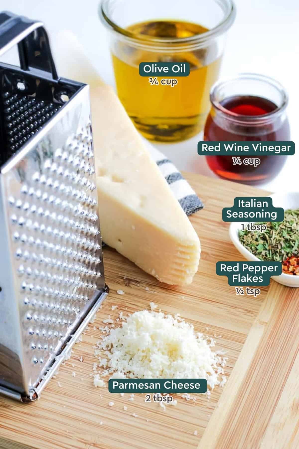 Ingredients for Italian salad dressing, including olive oil, red wine vinegar, Italian seasoning, red pepper flakes, and Parmesan.