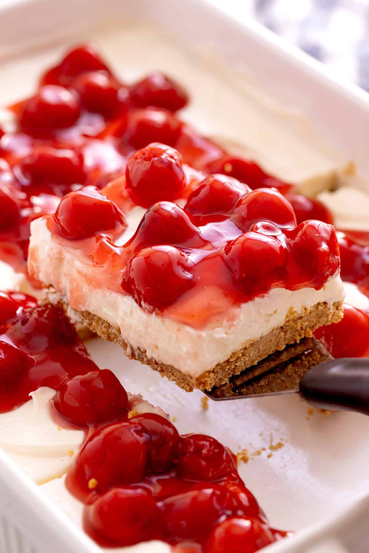 Lifting slice of no-bake cheesecake from pan.