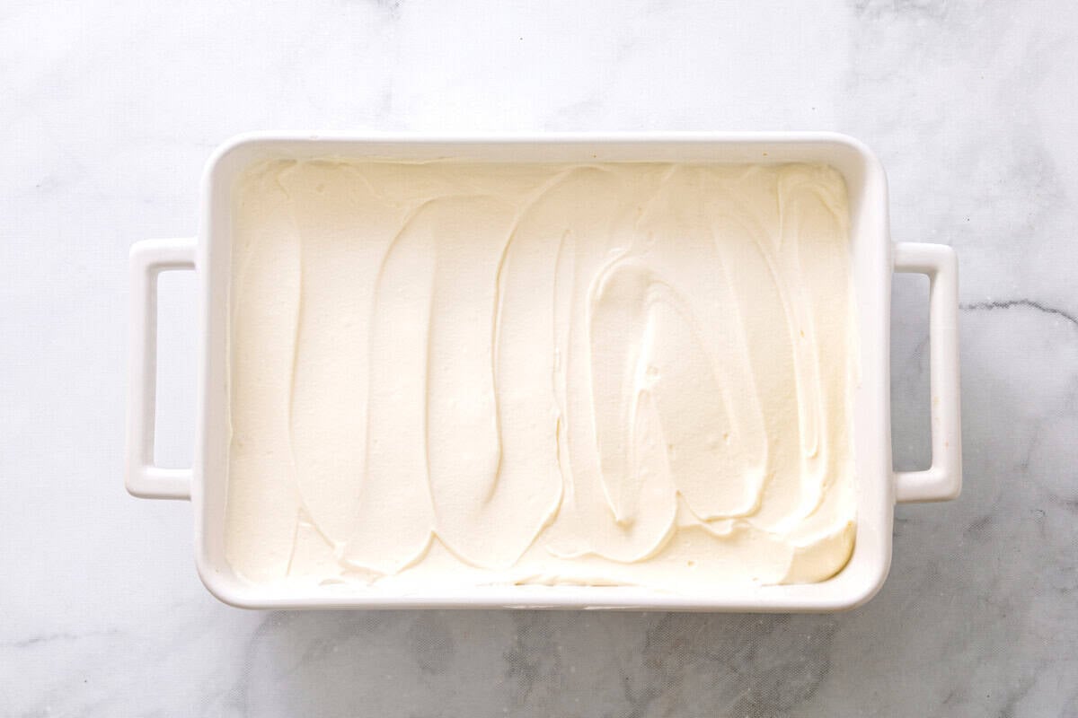 No bake cheesecake filling spread over crust in pan.