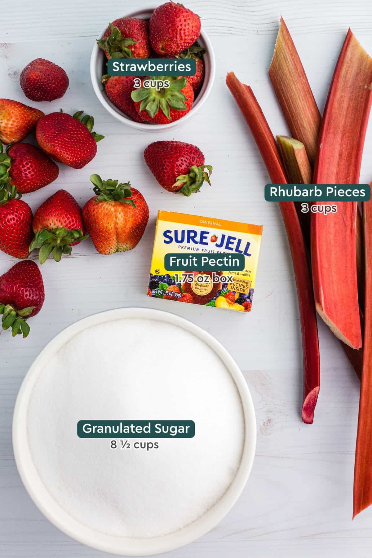 Ingredients for strawberry rhubarb jam, including strawberries, rhubarb, pectin, and sugar.