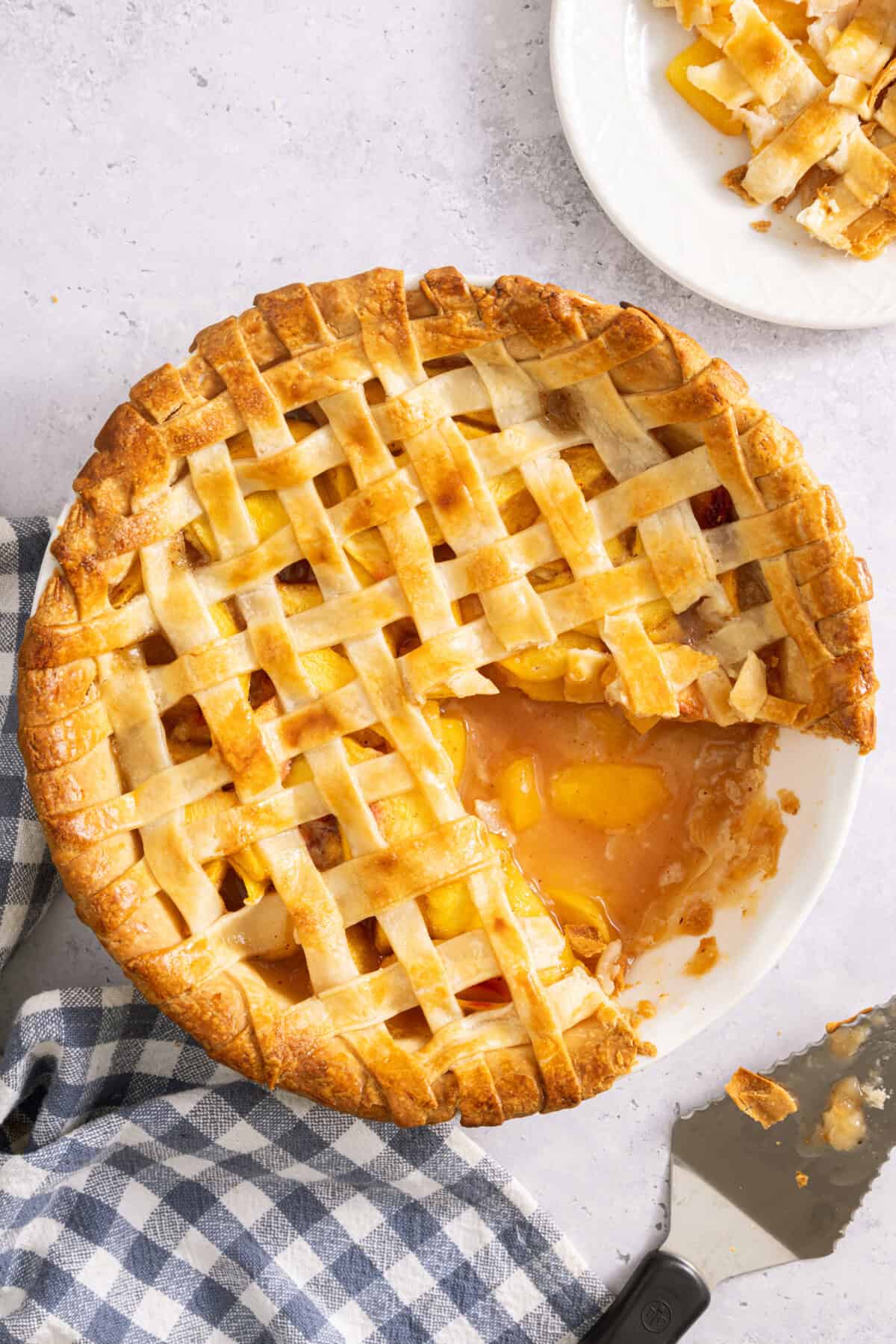 Lattice top peach pie with slice removed to show filling.
