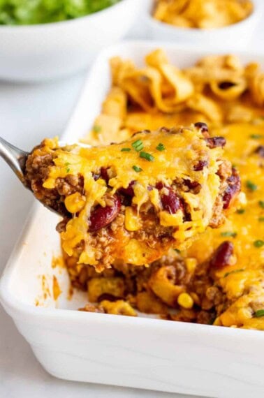 scoop of frito pie topped with shredded cheese