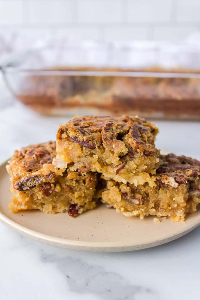 stack of three pecan pie bars served on a tan plate