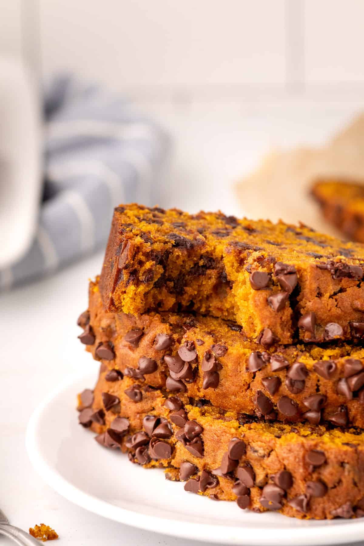 stack of three sliced chocolate chip pumpkin bread with a bite taken out of one