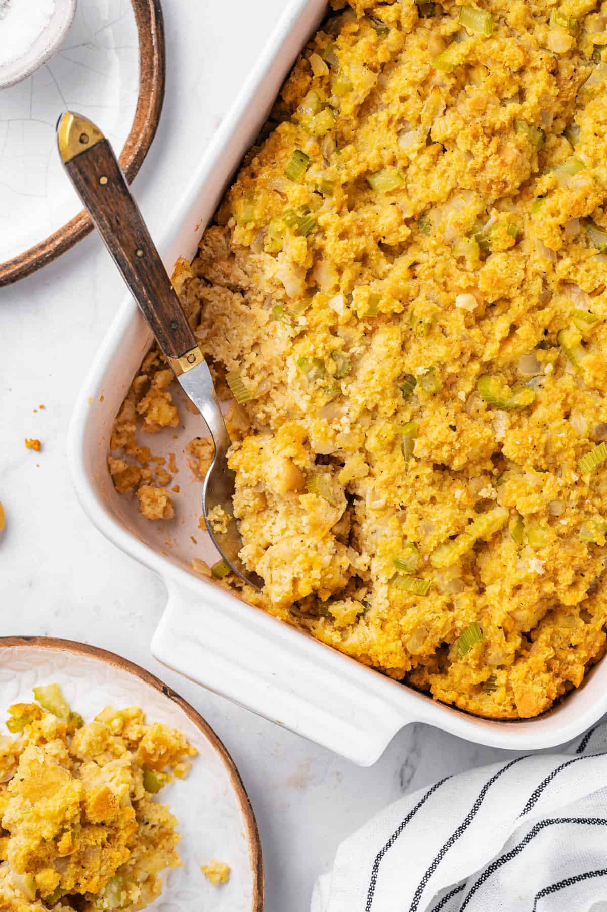 cornbread dressing in a casserole dish with a spoon