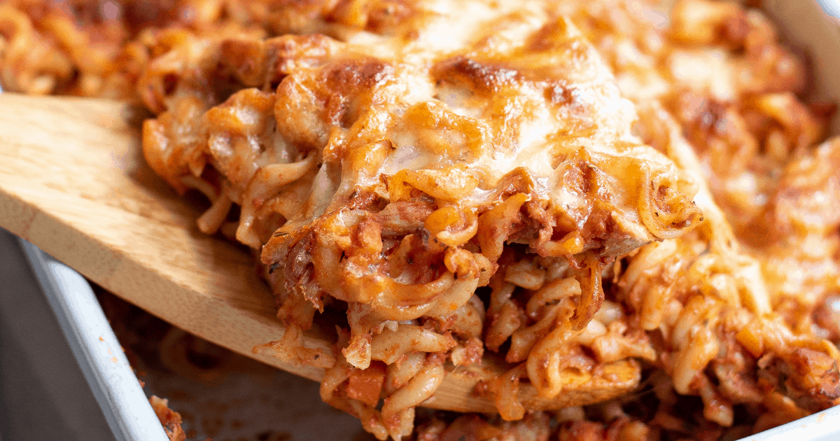 close up of turkey casserole with wooden spoon digging in