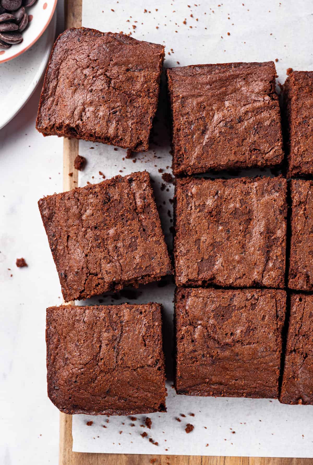 baked and cut homemade brownies into squares sitting on parchment paper