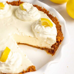lemon cream pie with graham cracker crust served in a pie dish.