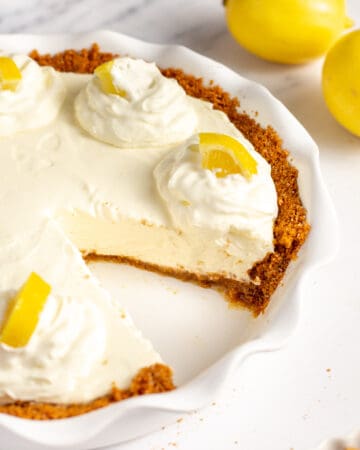 lemon cream pie with graham cracker crust served in a pie dish