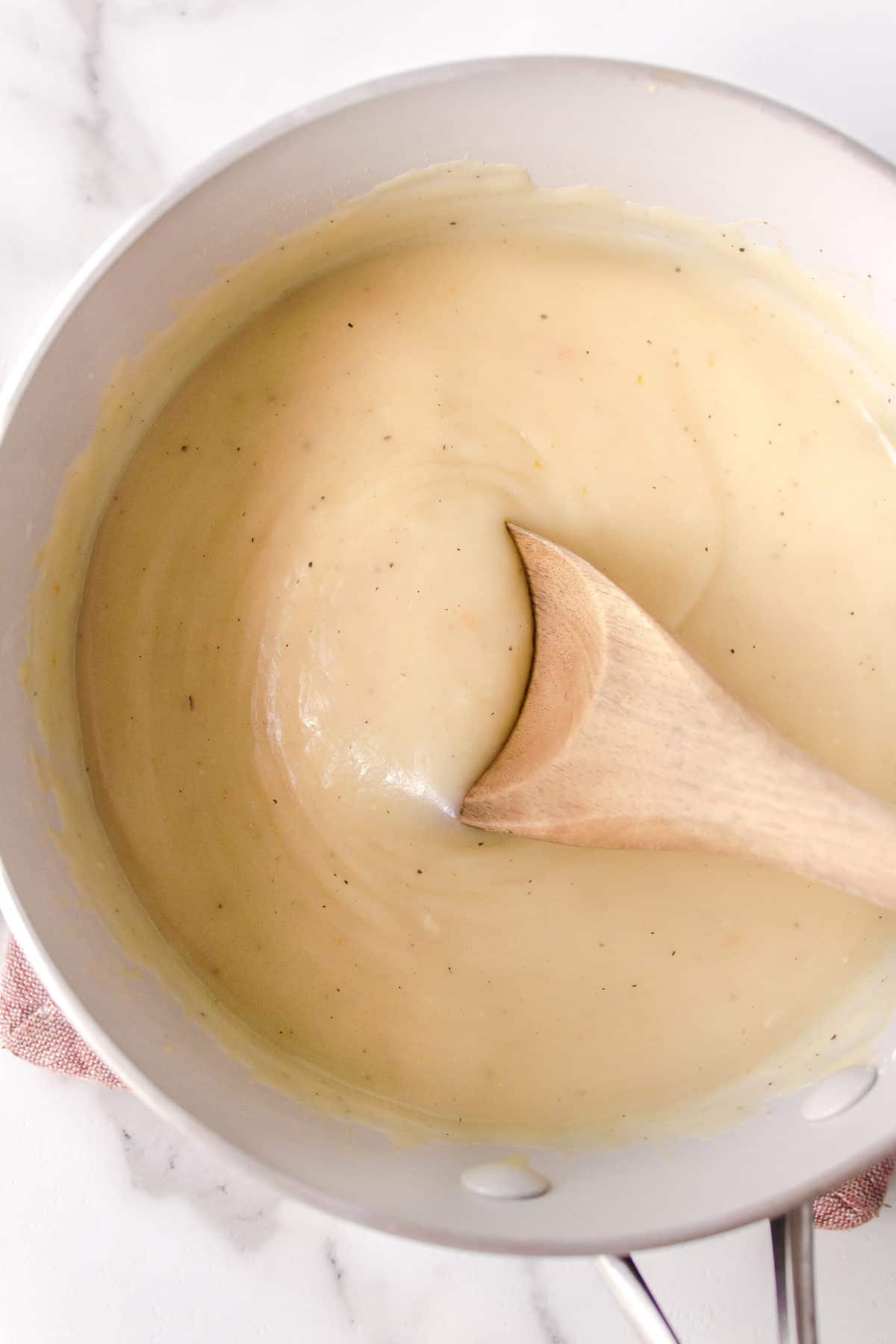 turkey gravy in a saucepan with a wooden spoon
