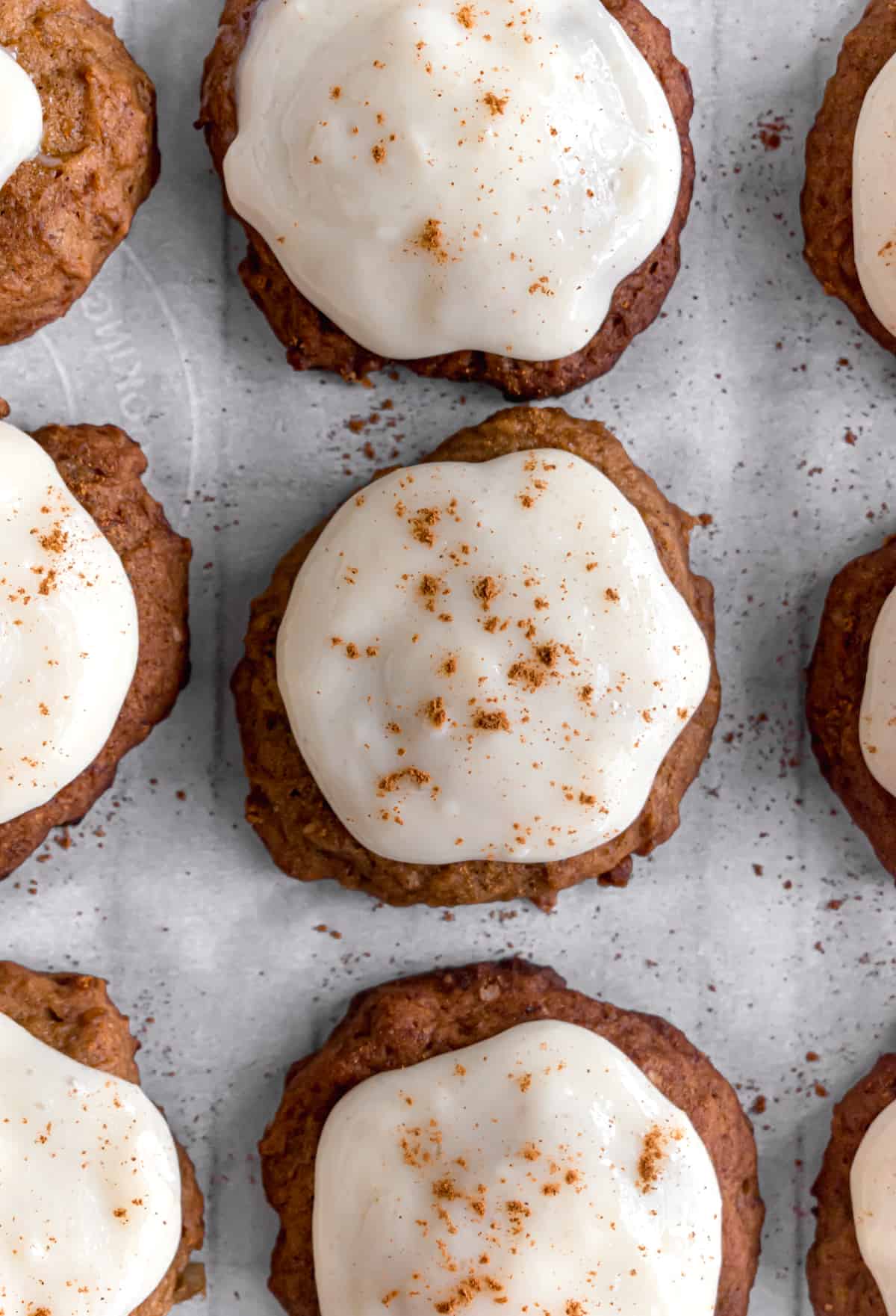 pumpkin cookies with cream cheese frosting on a baking sheet