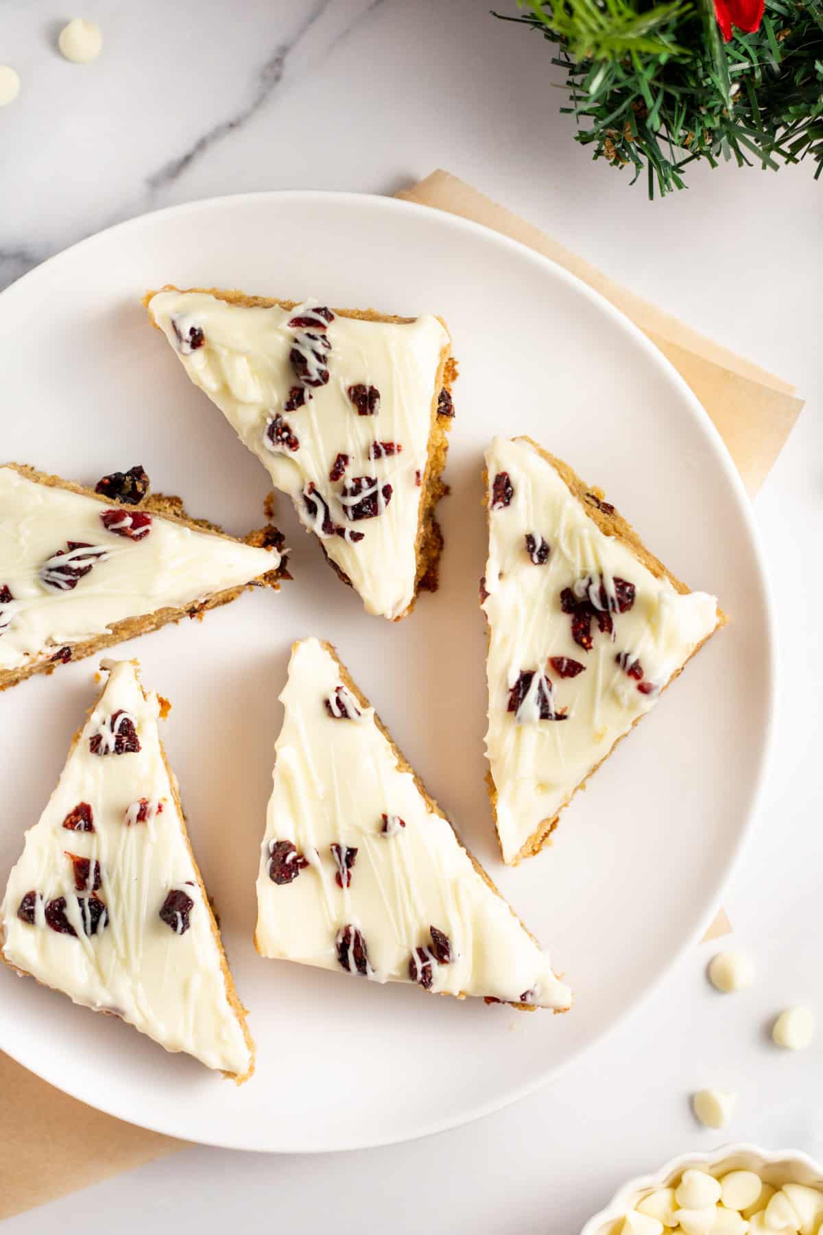 cranberry bliss bars cut into triangles served on a white plate.