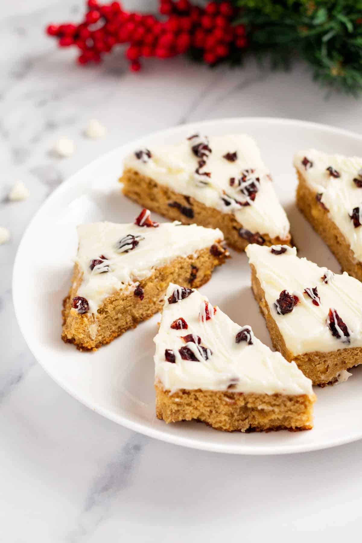 cranberry bliss bars cut in triangles served on a white plate.